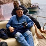 Murray November on boat with camera in Italy